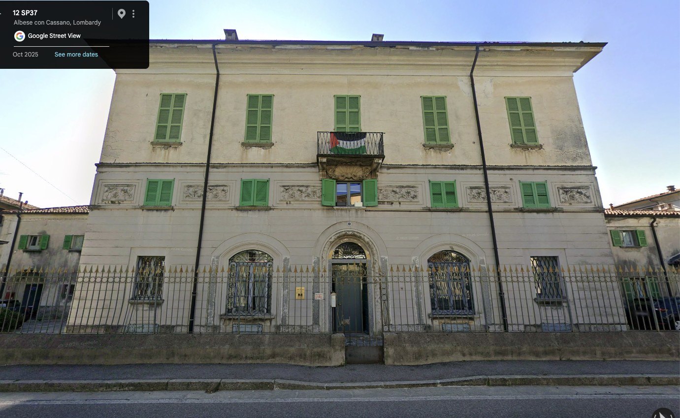 La facciata della casa di Via Vittorio Veneto 12 ad Albese con Cassano, con le persiane verdi e il balcone centrale.